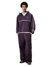 Oversized purple half-zip track jacket with embroidery-inspired design