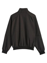 A black lightweight bomber jacket with a mock neck, raglan sleeves, and elasticized cuffs and hem, shown from the back on a light gray background.