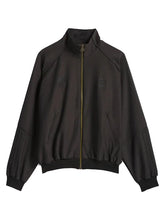 A dark brown zip-up jacket with a stand-up collar, ribbed cuffs and hem, and subtle tonal embroidered logos on the chest, displayed against a light gray background.