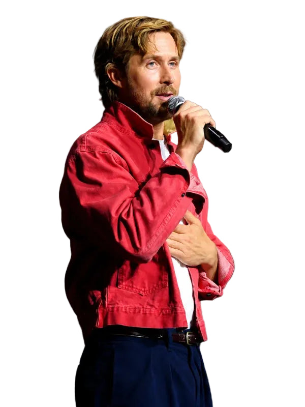 A man with blond hair and a beard stands on a stage holding a microphone, wearing a red jacket over a white shirt and dark trousers. Comic-Con International logos are visible in the background.