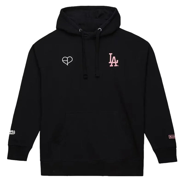 A black pullover hoodie with a white heart outline logo on the left chest and a pink 'LA' logo on the right chest, displayed on a light gray background.