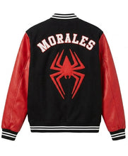 A black and red varsity jacket shown from the back, featuring 'MORALES' in white block letters and a large red spider emblem on the back. The jacket has red faux-leather sleeves and ribbed black, white, and red striped collar, cuffs, and hem.