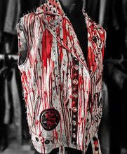 A sleeveless gothic-style vest displayed on a black mannequin torso. The vest features a white base covered in dramatic red blood-splatter and drip patterns, with black distressed detailing, silver-tone studs, and a large circular red-and-black emblem on the lower left front.