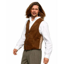 A man wearing a brown suede vest over a white long-sleeve shirt and gray trousers, photographed against a plain white background.