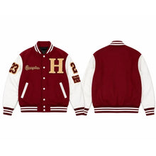 A maroon and white varsity jacket shown from both the front and back views. The front features a large gold letter 'H' on the chest, 'Champions' script on the right sleeve, and the number '23' on the left sleeve.