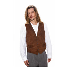 A man wearing a brown suede vest over a white long-sleeve shirt and gray trousers, photographed against a plain white background.