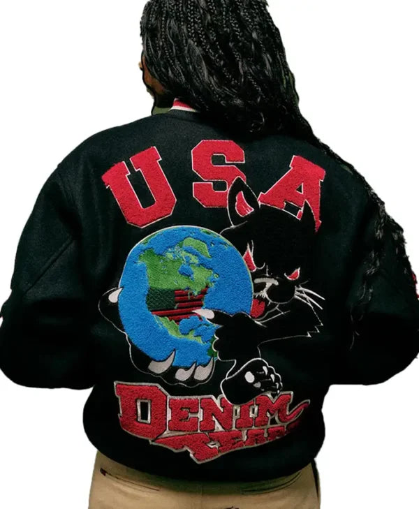 A person viewed from the back wearing a black varsity-style jacket with a large red 'USA' and 'DENIM JAYS' graphic, plus a black cat and blue globe patch on the back.