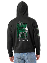 A person shown from the back wearing a black pullover hoodie with a large green, white, and gray graphic print on the back and the word 'EAGLES' below it, paired with blue jeans against a light gray studio background.