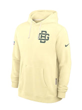 A light cream-colored Nike pullover hoodie with a dark green 'UC' logo on the chest and a green Nike swoosh on the sleeve, shown on a light gray background.