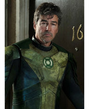 A man in a distressed green and black armored costume with a glowing green emblem on the chest, standing in front of a dark wooden door with the number 16.