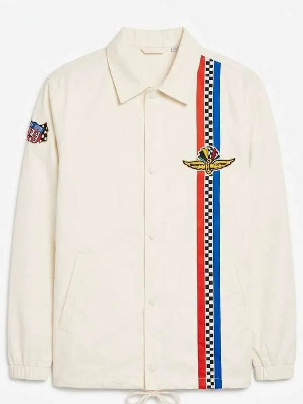 An off-white Coach jacket featuring a vertical red and blue checkered stripe down the front, a gold winged patch, and a small embroidered patch on the sleeve.