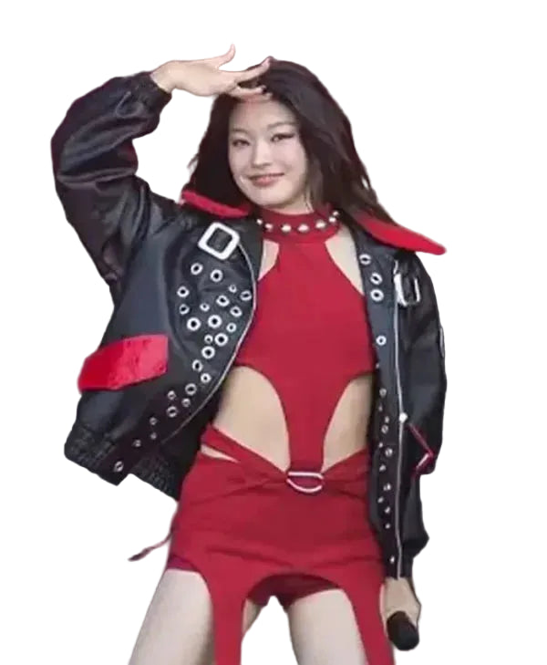 A woman posing on stage in a red cutout mini dress and a black leather jacket with red accents and silver studs.