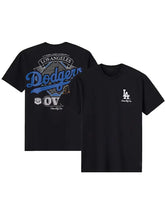 Black Los Angeles Dodgers t-shirt shown from both front and back. The front features a small white LA logo on the left chest, and the back displays a large graphic with 'Los Angeles Dodgers' in blue and white.