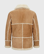 A tan shearling-style jacket shown from the back, featuring a warm camel-brown suede-like body with contrasting off-white/cream shearling lining along the collar, cuffs, and panel seams, set against a solid light gray background.