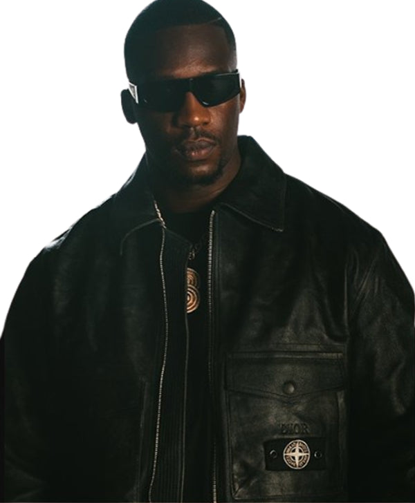 A man wearing a black leather jacket with a visible Stone Island badge on the pocket and dark sunglasses, shown against a plain white background.