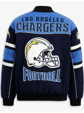 Los Angeles Chargers football jacket shown from the back, featuring a navy blue body, light blue shoulders, white and blue lettering, and a large Chargers helmet graphic in the center.