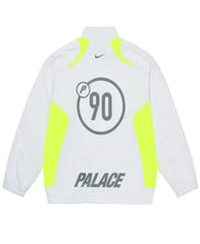 White Palace track jacket with neon yellow-green side panels and collar trim, featuring a gray '90' circle graphic on the back, a small black Nike swoosh, and 'PALACE' printed in gray.