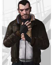 A man wearing a dark brown leather jacket over a white zip-up sweater, black turtleneck, and black fingerless gloves, shown against a light gray background with a blurred rectangular overlay.