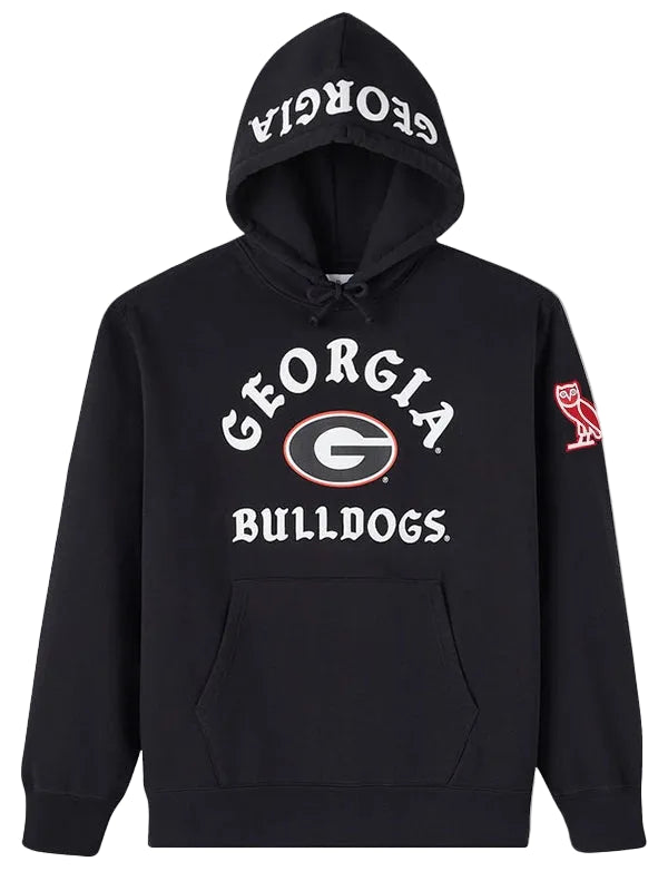 A black pullover hoodie featuring the Georgia Bulldogs logo on the front, with 'GEORGIA BULLDOGS' printed in white on the chest and hood, and a red owl logo on the sleeve.