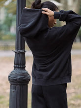Unisex black hoodie with hooded collar and rib-knitted cuffs