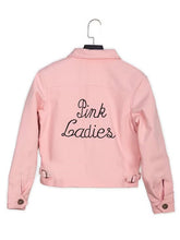 A light pink cropped jacket with 'Pink Ladies' embroidered in black script across the back, shown on a black hanger against a white background.
