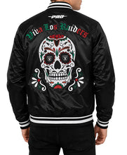A man wearing a black satin bomber jacket, viewed from the back. The jacket features a large colorful sugar skull graphic with the words 'Viva Los Raiders' in green and red.