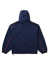 A navy blue hooded jacket shown from the back, featuring bright red contrast piping along the shoulders and sleeves, set against a solid light gray background.