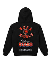 A black hoodie shown from the back, featuring a large Chicago Bears graphic with red and white text and a bear head logo on a light gray background.