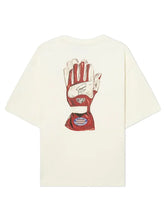 An oversized cream-colored t-shirt shown from the back, featuring a large graphic print of a red and white goalkeeper glove with a signature on the back.