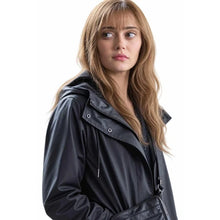 A woman with long light brown hair wearing a black hooded rain jacket, photographed against a solid white background.