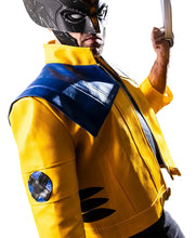 A person wearing a Wolverine-style costume jacket in bright yellow with dark blue shoulder panels and a black mask, posed against a dark studio background while holding a small object in one hand.