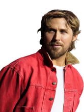 A man wearing a red denim-style jacket over a white t-shirt, photographed in a real event or studio setting with a blurred background.