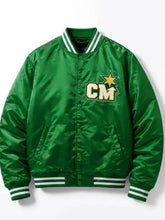 A green satin varsity jacket with white striped ribbed collar, cuffs, and hem, featuring a gold embroidered star and 'CM' lettering on the chest.