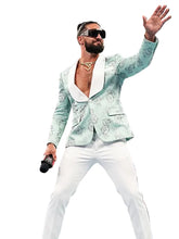 Seth Rollings in a wrestling ring wearing a light mint green patterned blazer with white lapels, white pants, and sunglasses, holding a microphone and waving to the crowd.