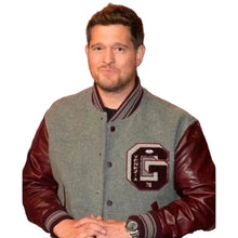 A man wearing a gray and burgundy varsity jacket with a large 'G' and 'OKLAHOTA 78' patch on the chest, posed against a dark studio background with blue lighting.
