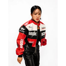 A woman modeling a red, black, and white racing-inspired leather jacket with prominent 'HARSH.' and 'RACING' text, paired with black leather pants against a plain white background.