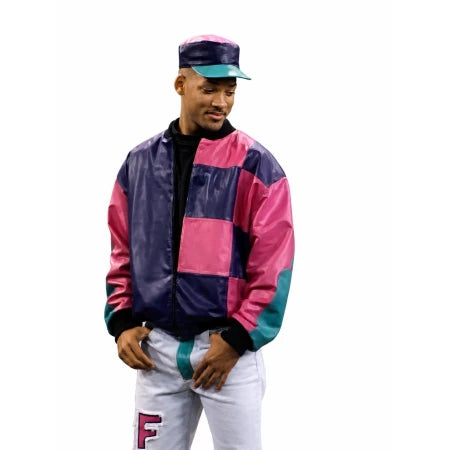 A man wearing a colorful patchwork bomber jacket with pink, purple, and teal panels, paired with white pants and a matching cap, isolated on a white background.
