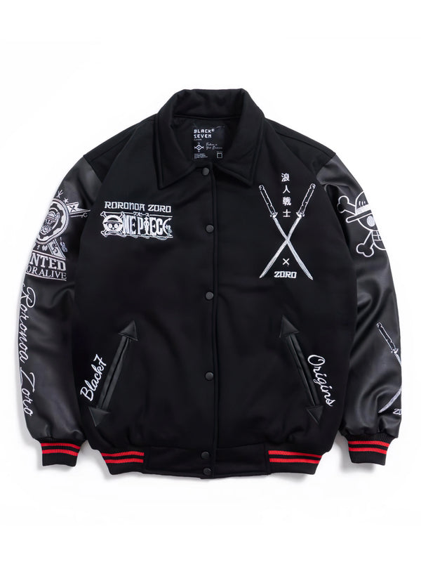 A black varsity-style bomber jacket with black leather sleeves, featuring white graphic prints and text on the front and sleeves, red and black striped ribbed cuffs and hem, and snap-button closure.
